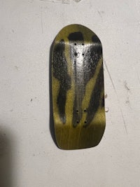 a green and black skateboard on a white wall